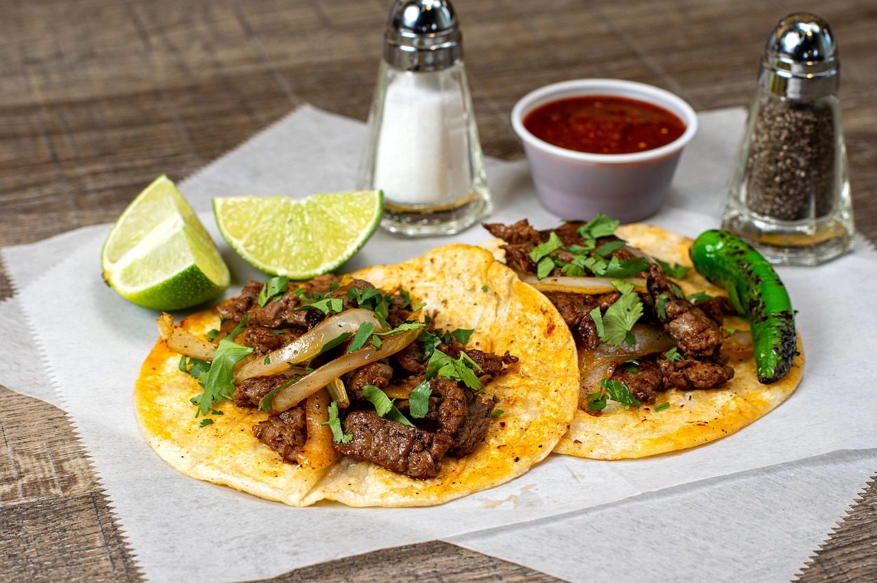 Tacos with seasoned beef, corn tortillas, lime and cilantro